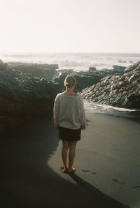 Rear view of woman looking at sea against sky