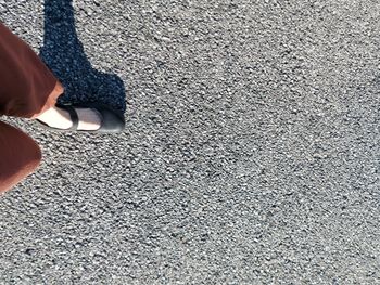 Low section of woman standing on road