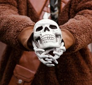 Close-up of person holding human skull