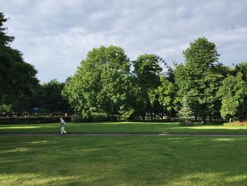 Man playing soccer on field against trees