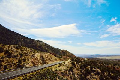 Scenic view of road amidst mountains against sky