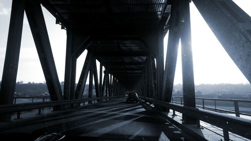 Bridge over river in city against sky