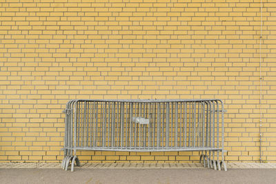 Metal fence against brick wall