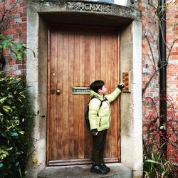 Rear view of boy standing by door