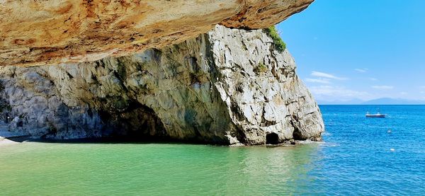 Scenic view of rock formation in sea against sky