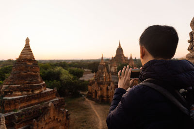 Rear view of people at temple against clear sky