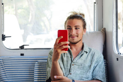 Portrait of woman using mobile phone while sitting in bus