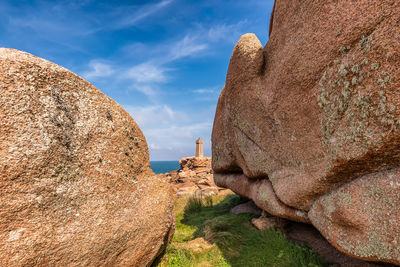 Scenic view of men ruz lighthouse in brittany france between two giant red rocks