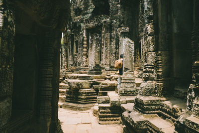 Rear view of man standing at old ruins temple