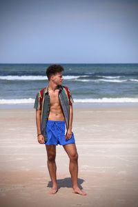 Full length of young man standing at beach