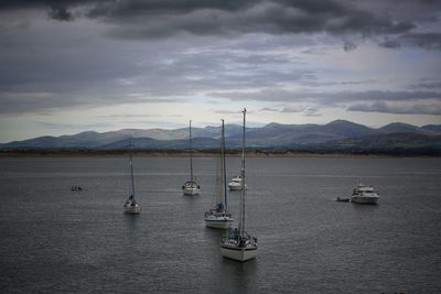 Sailboats in sea against sky