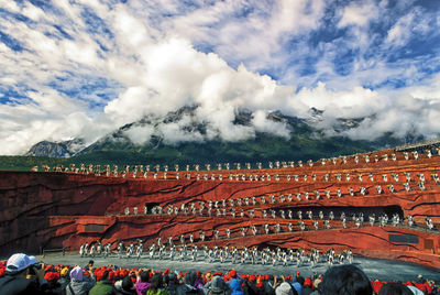 People at town square against cloudy sky