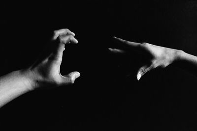 Cropped image of hand over black background