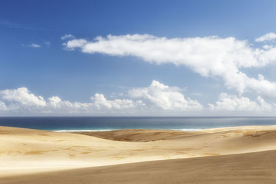 Scenic view of beach against blue sky