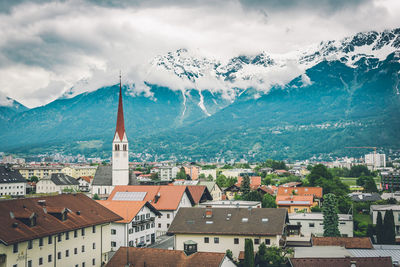 Aerial view of townscape and mountains against sky