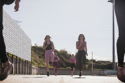 Female athletes running on sunny day