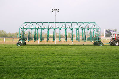 People on grassy field against clear sky