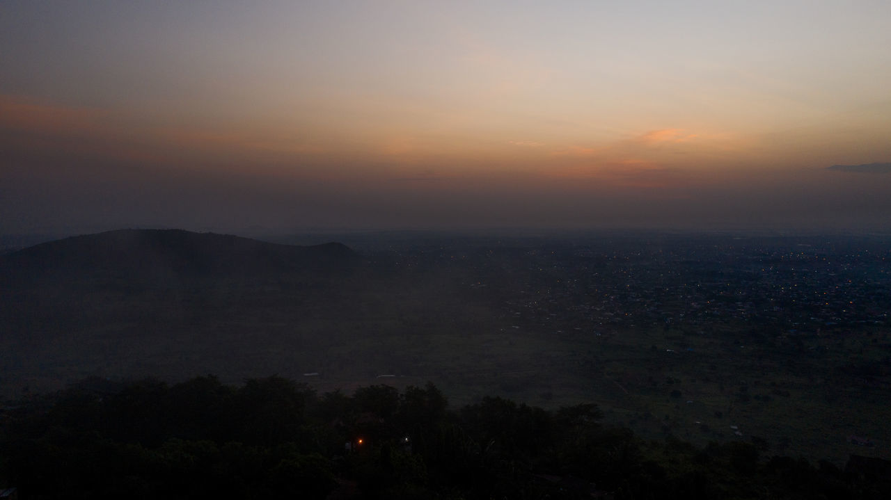 HIGH ANGLE VIEW OF SILHOUETTE CITY AGAINST SKY DURING SUNSET