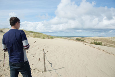 Man standing on beach against sky