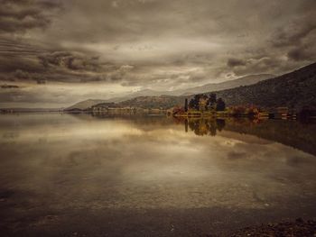 Scenic view of lake by mountains against sky