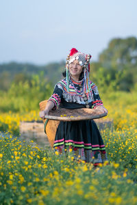 Woman holding umbrella standing on field