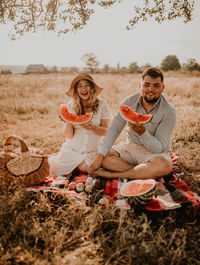 Portrait of smiling woman holding food at farm