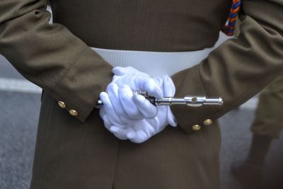 Midsection of man holding metal