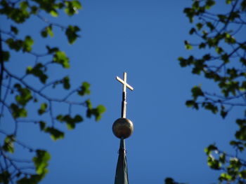 Low angle view of communications tower against clear blue sky