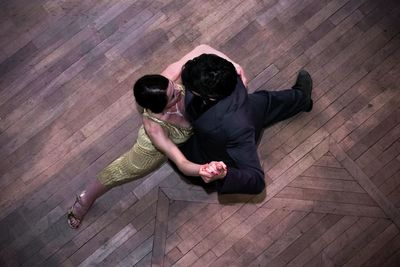 High angle view of couple kissing on floor