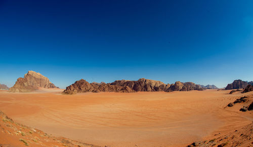 Scenic view of desert against clear blue sky