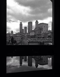 Buildings in city against cloudy sky