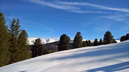 Snow covered landscape against blue sky