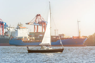 Sailboats in sea against sky