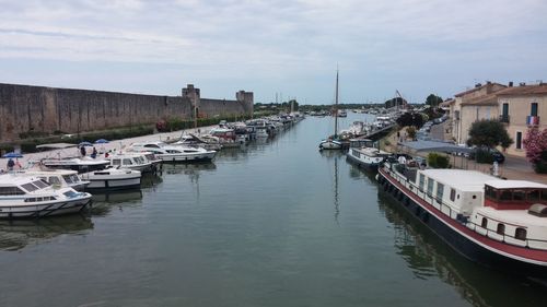 Sailboats moored at harbor