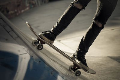 Low section of man skateboarding in park