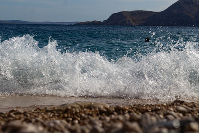 Water splashing in sea against sky