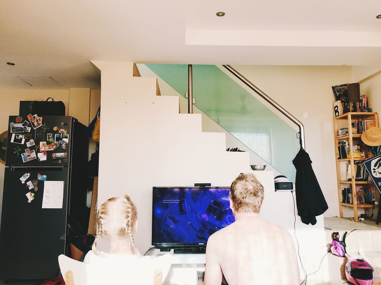 REAR VIEW OF PEOPLE SITTING IN CORRIDOR AT HOME