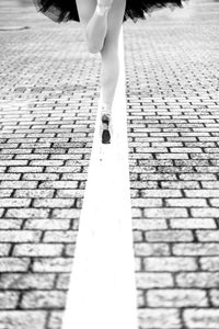 Low section of woman dancing on footpath