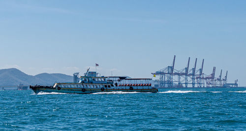 Ship sailing in sea against clear blue sky