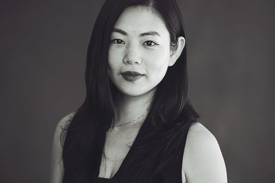 Portrait of beautiful young woman against black background