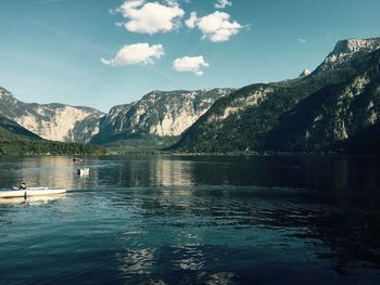 Scenic view of lake by mountains against sky