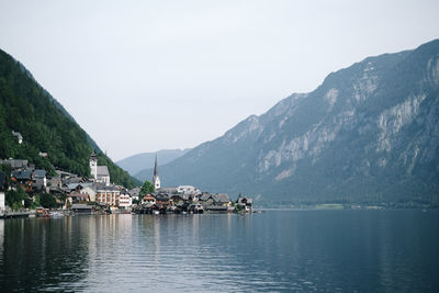 Scenic view of sea by townscape against sky