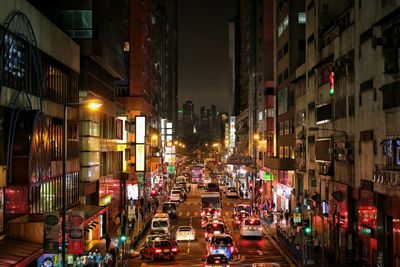 Cars on road amidst buildings in city at night