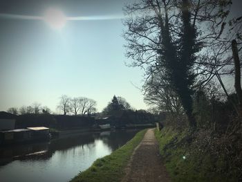 Canal amidst trees against sky