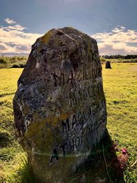 Close-up of rocks on field against sky