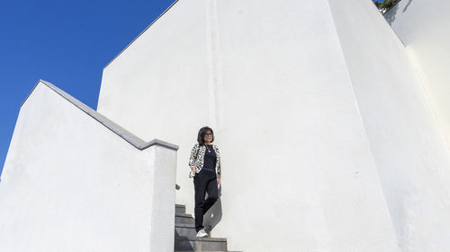 Low angle view of person standing on staircase against sky