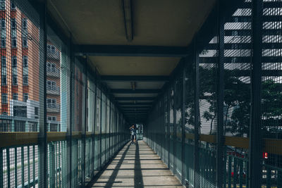 Rear view of man walking on footpath