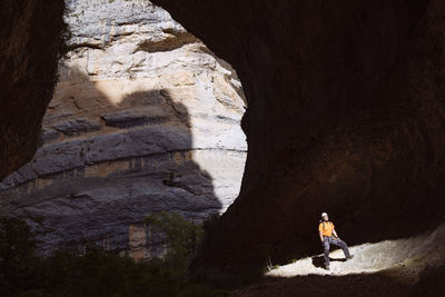 Sunlight falling on man standing in cave