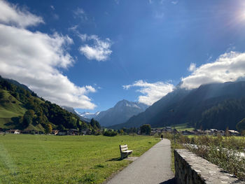 Road amidst green landscape against sky