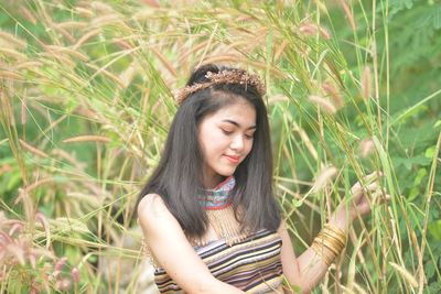 Beautiful young woman standing on field